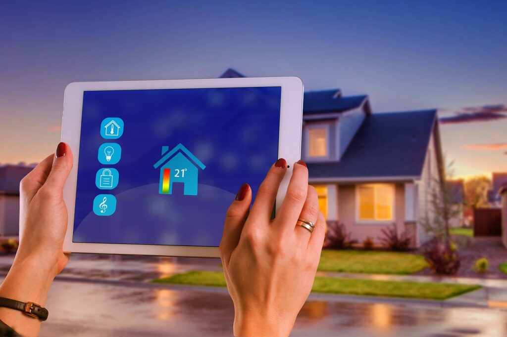 Personne contrôlant à distance la température de sa maison via une tablette, avec la maison visible en arrière-plan.